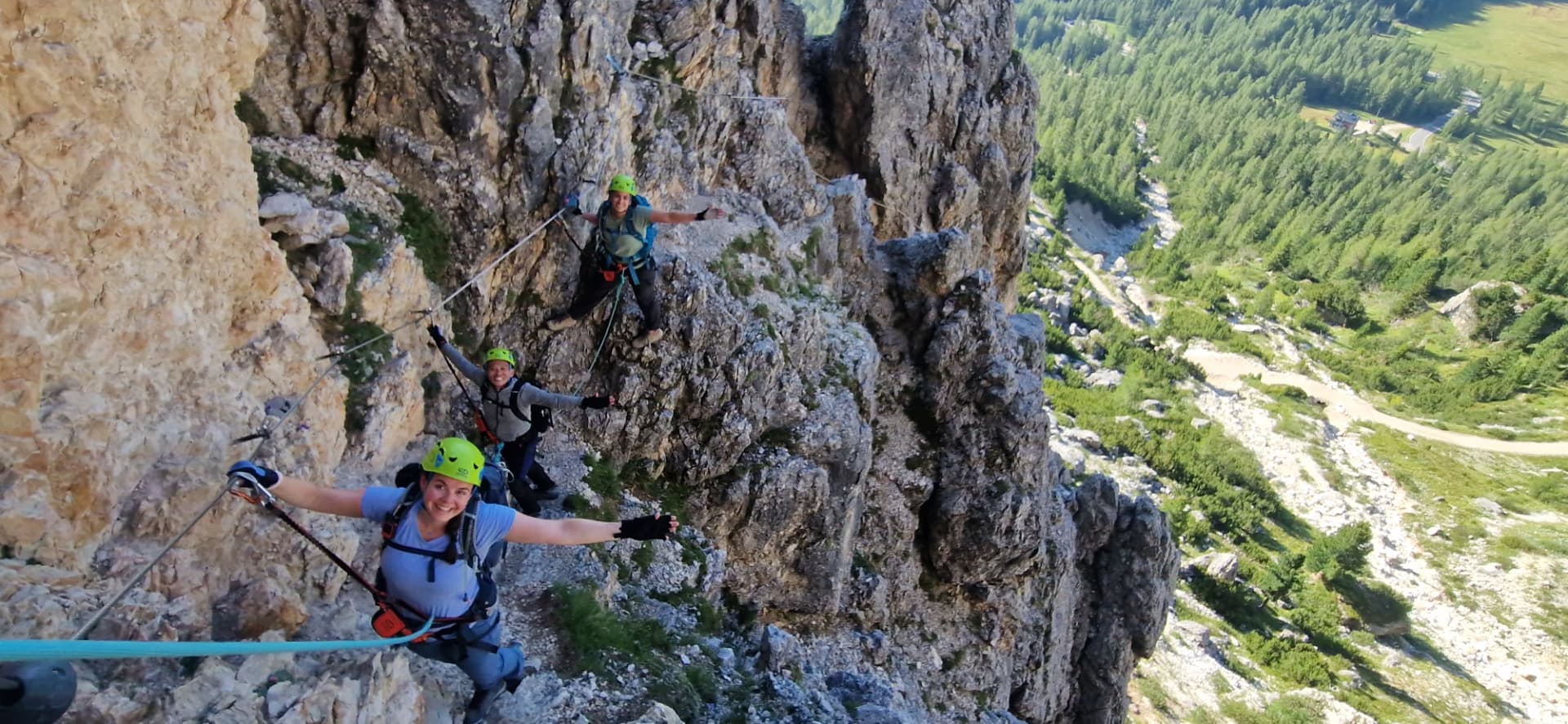 Group clipped to the cable on a panoramic via ferrata above Cortina