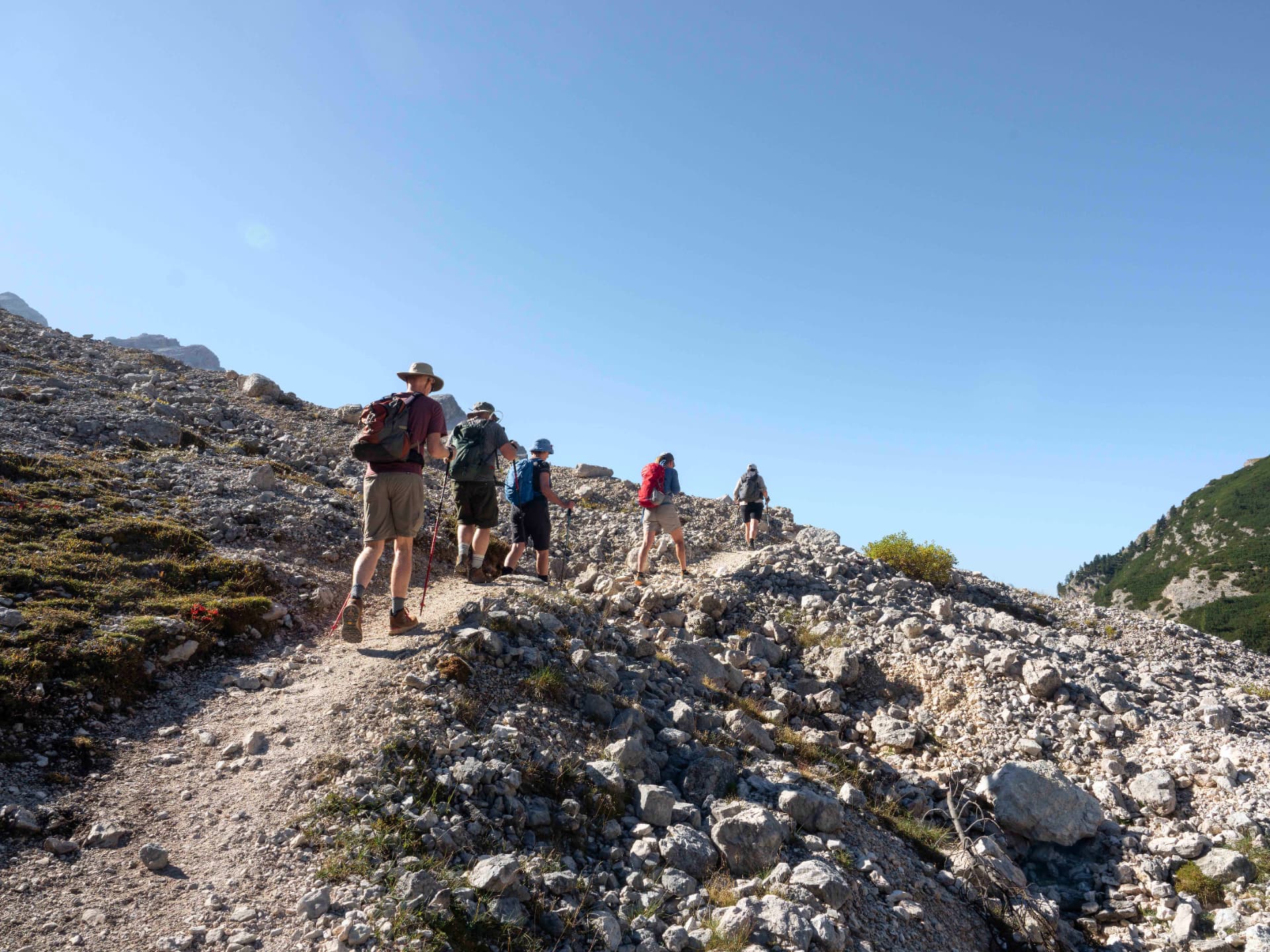 Group of hikers ascending a scree trail in the Dolomites
