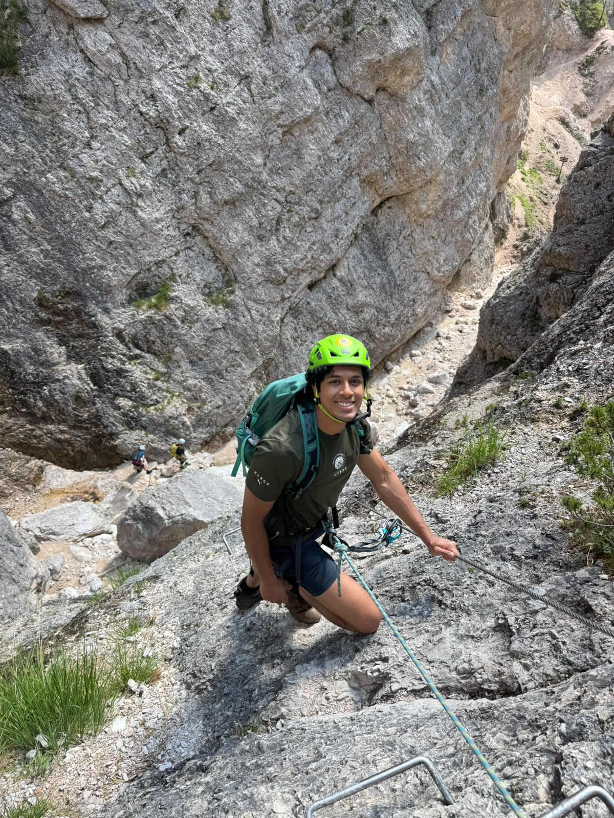 Climber with helmet and harness on a rocky via ferrata in the Cortina Dolomites